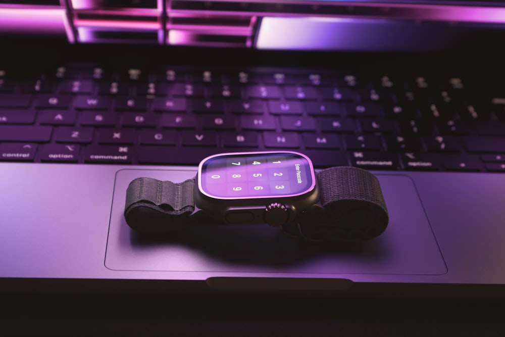 a smart watch sitting on top of a laptop keyboard