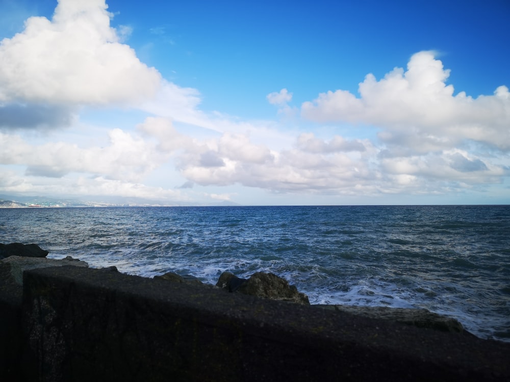 a large body of water sitting next to a rocky shore