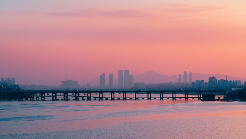 a bridge over a body of water with a city in the background