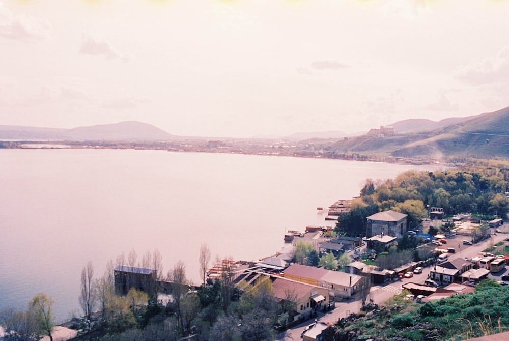 a view of a lake with houses and mountains in the background