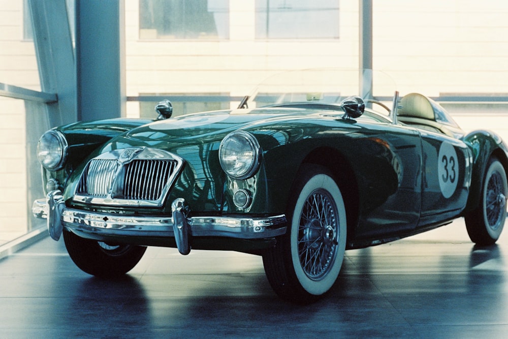 a green sports car parked inside of a building