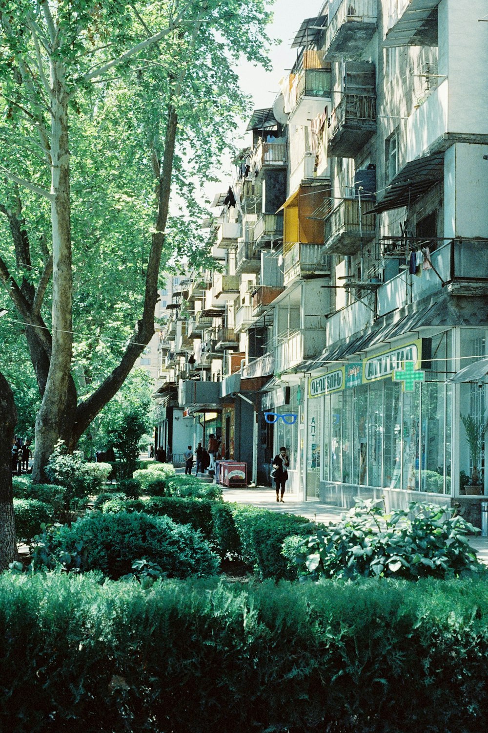 a group of people walking down a street next to tall buildings