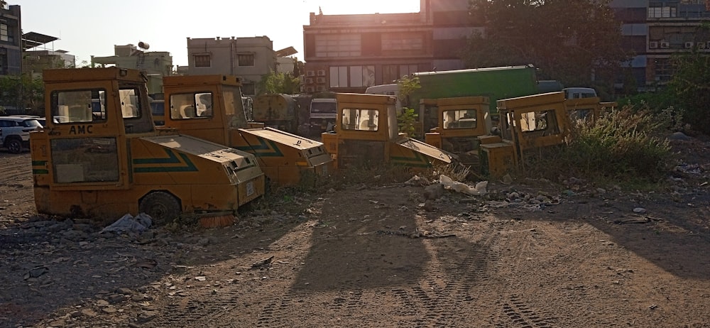 a group of dump trucks sitting on top of a dirt field