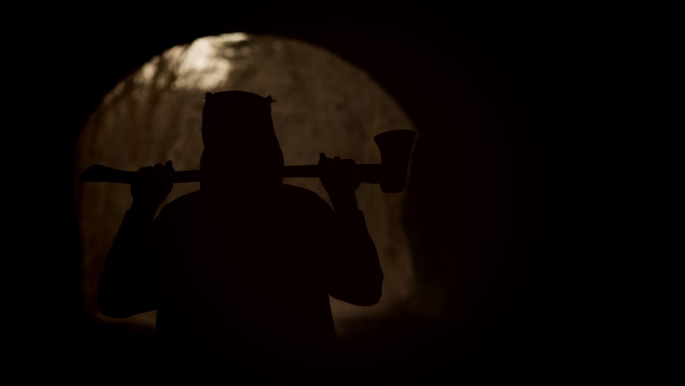 a silhouette of a man with a pipe in his hand