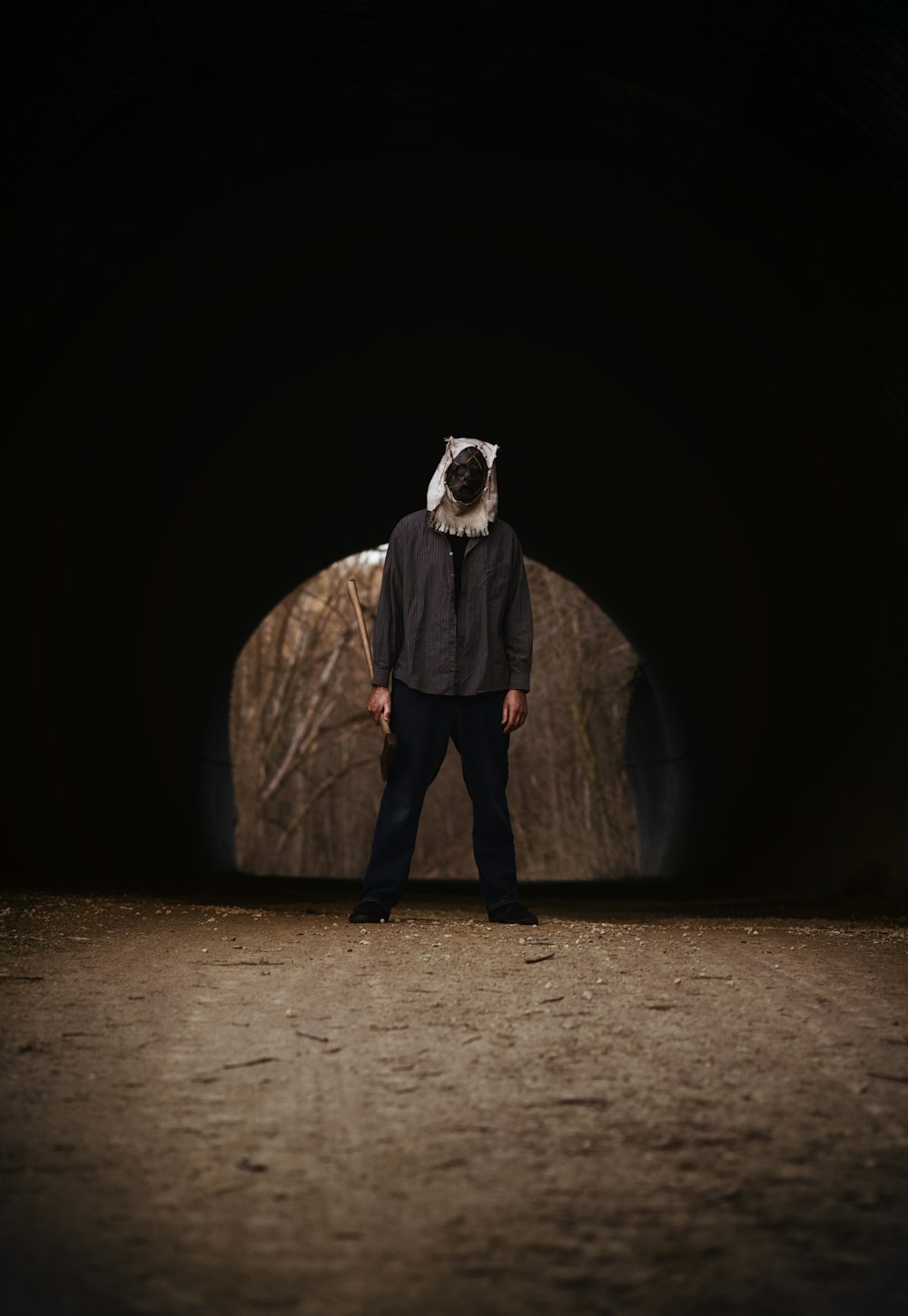 a man standing in a dark tunnel with a cow on his head