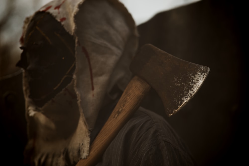 a close up of a bloody mask with an axe