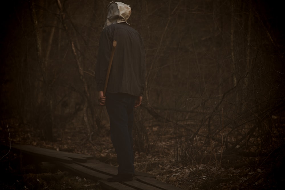 a person standing on a wooden platform in the woods