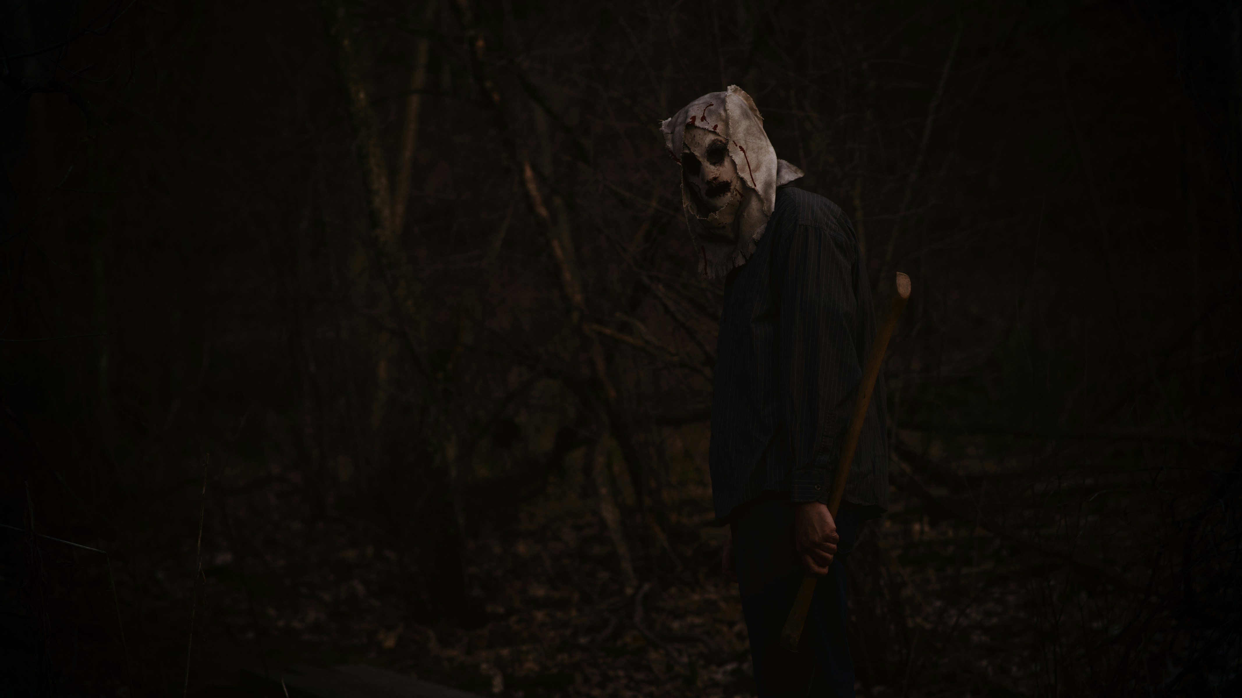 a man wearing a mask and holding a stick