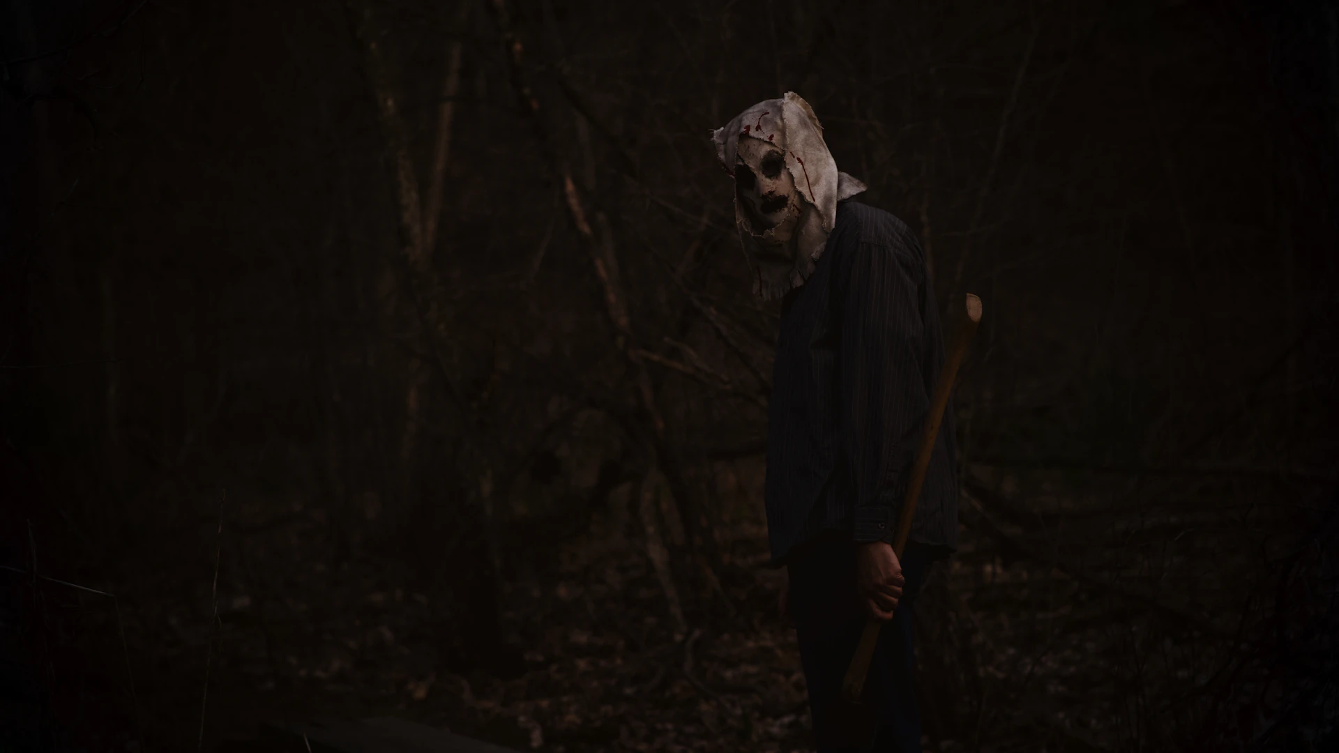 a man wearing a mask and holding a stick