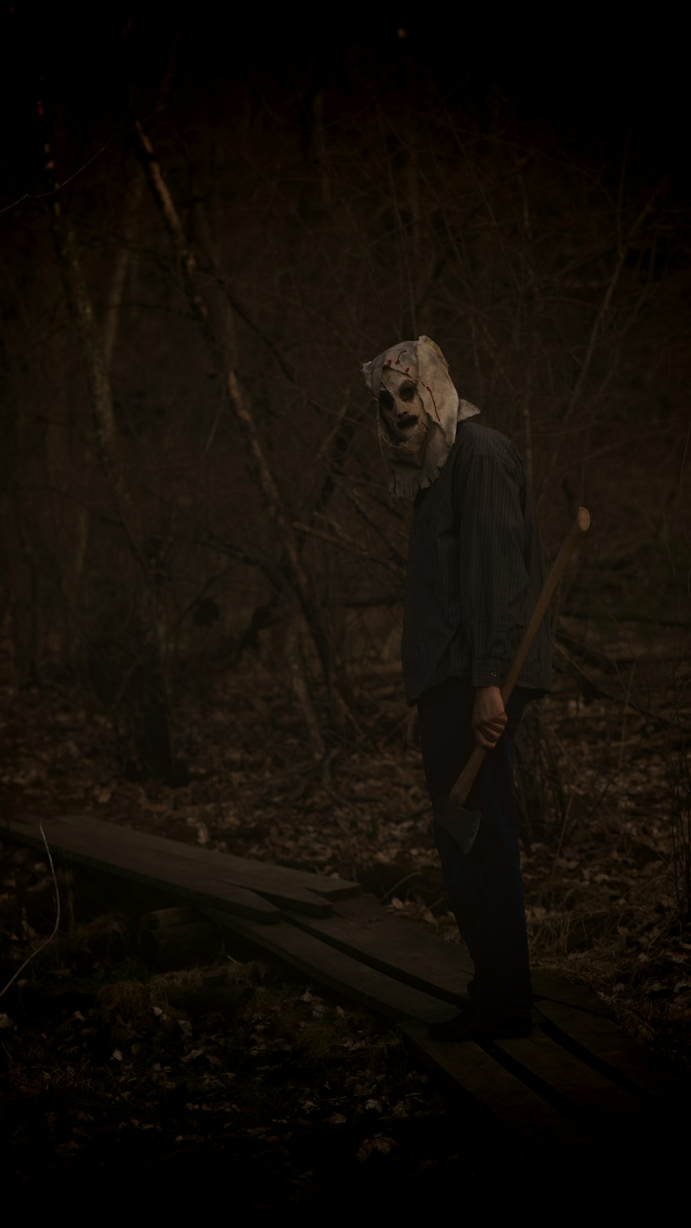 Un hombre con una máscara aterradora sosteniendo un palo