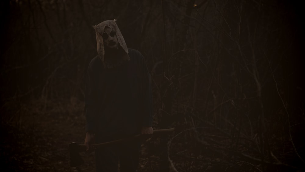 a person in a creepy costume holding a stick