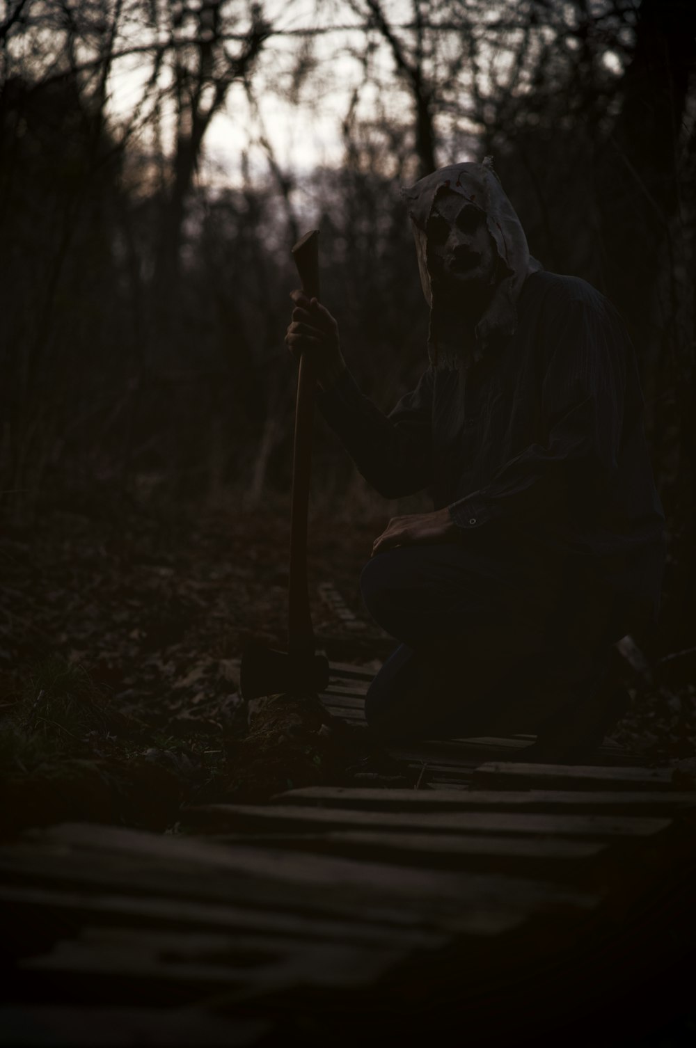 a scary looking man sitting in the woods
