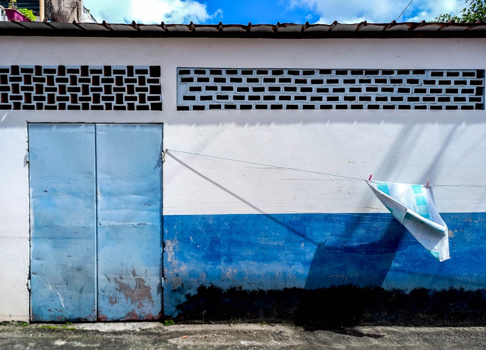 a blue and white building with a surfboard hanging from it's side