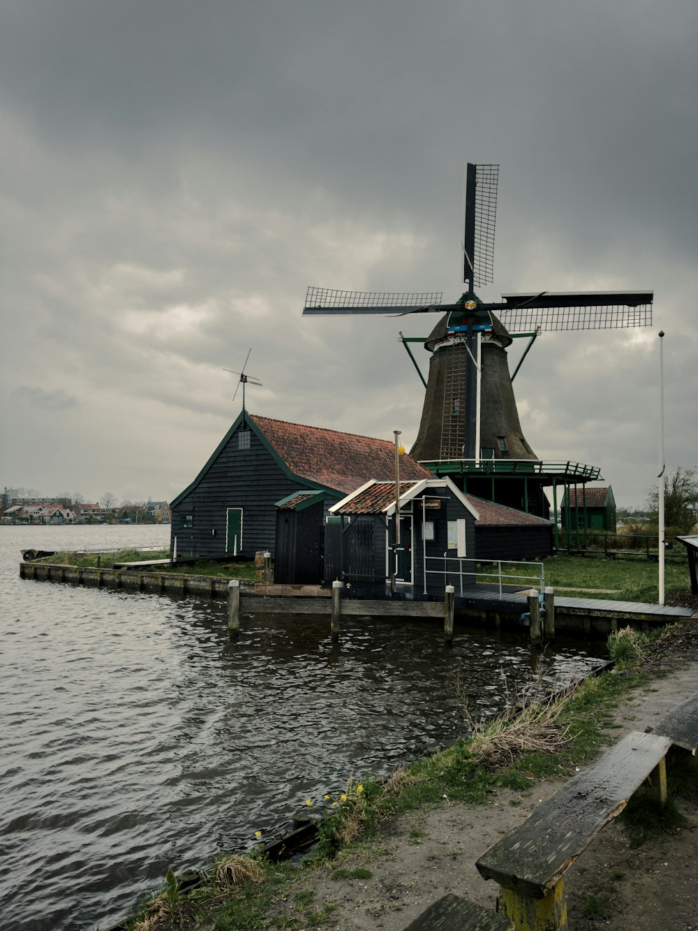 a windmill sitting next to a body of water
