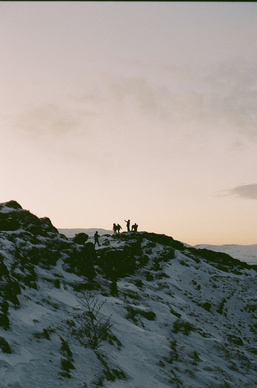 a group of people standing on top of a snow covered hill