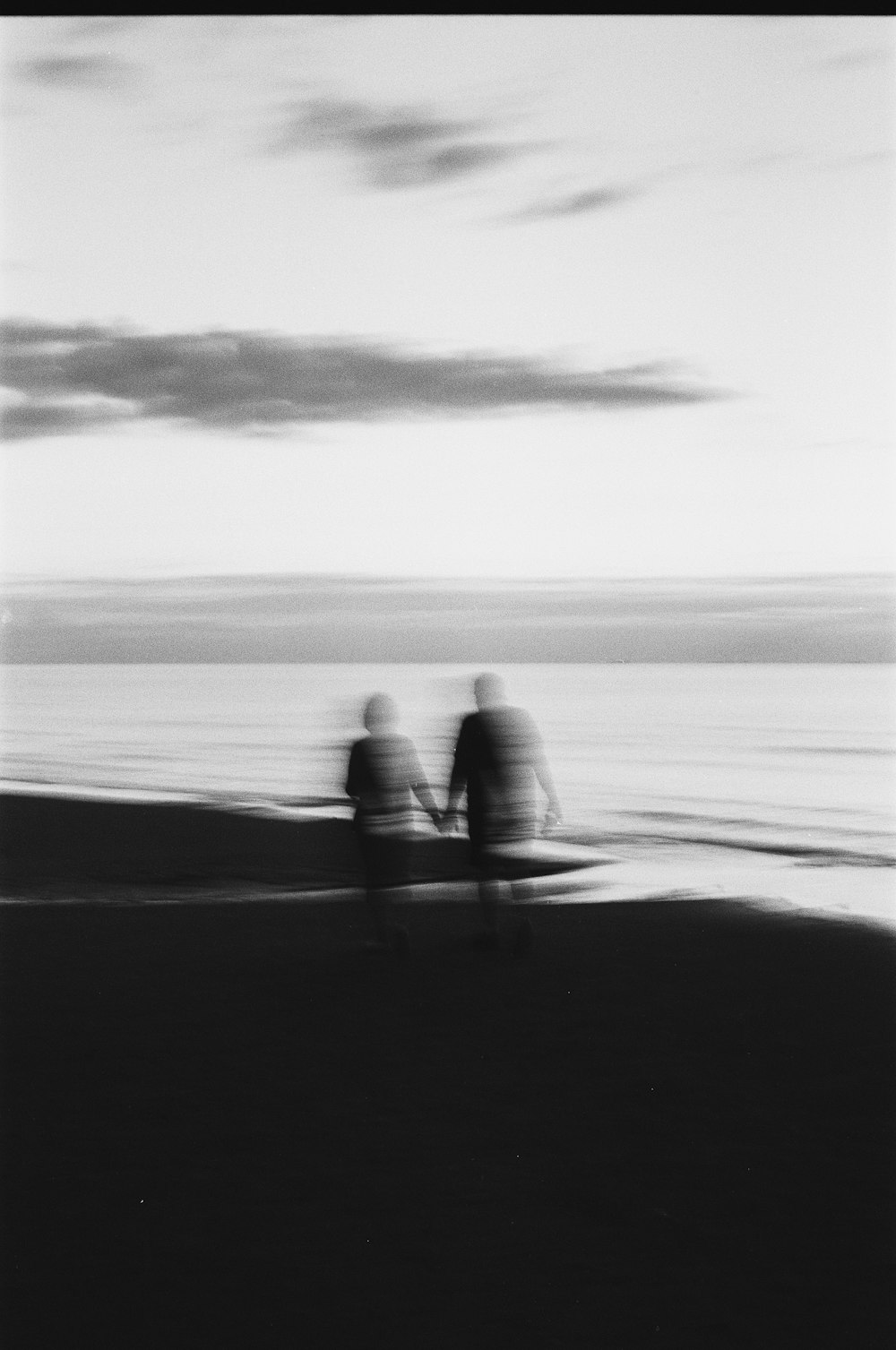 two people walking on the beach holding hands