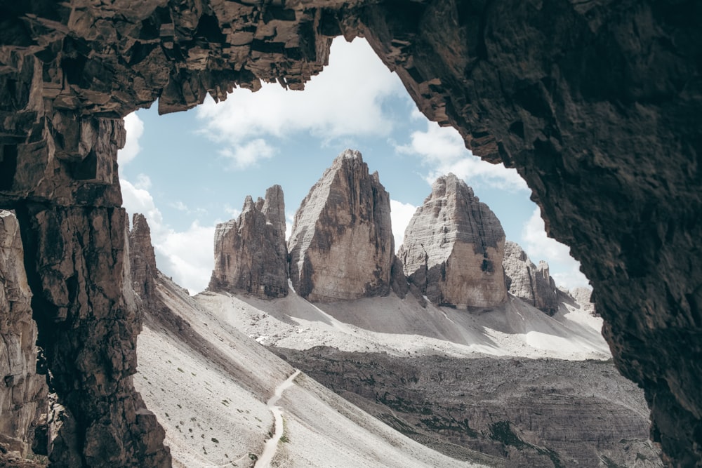 a view of a mountain range through a cave