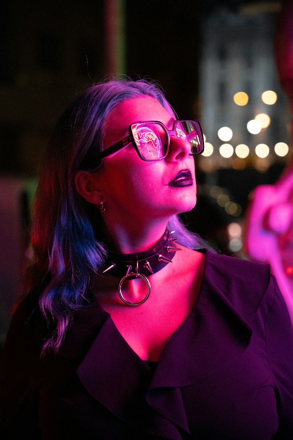 a woman wearing glasses and a choker