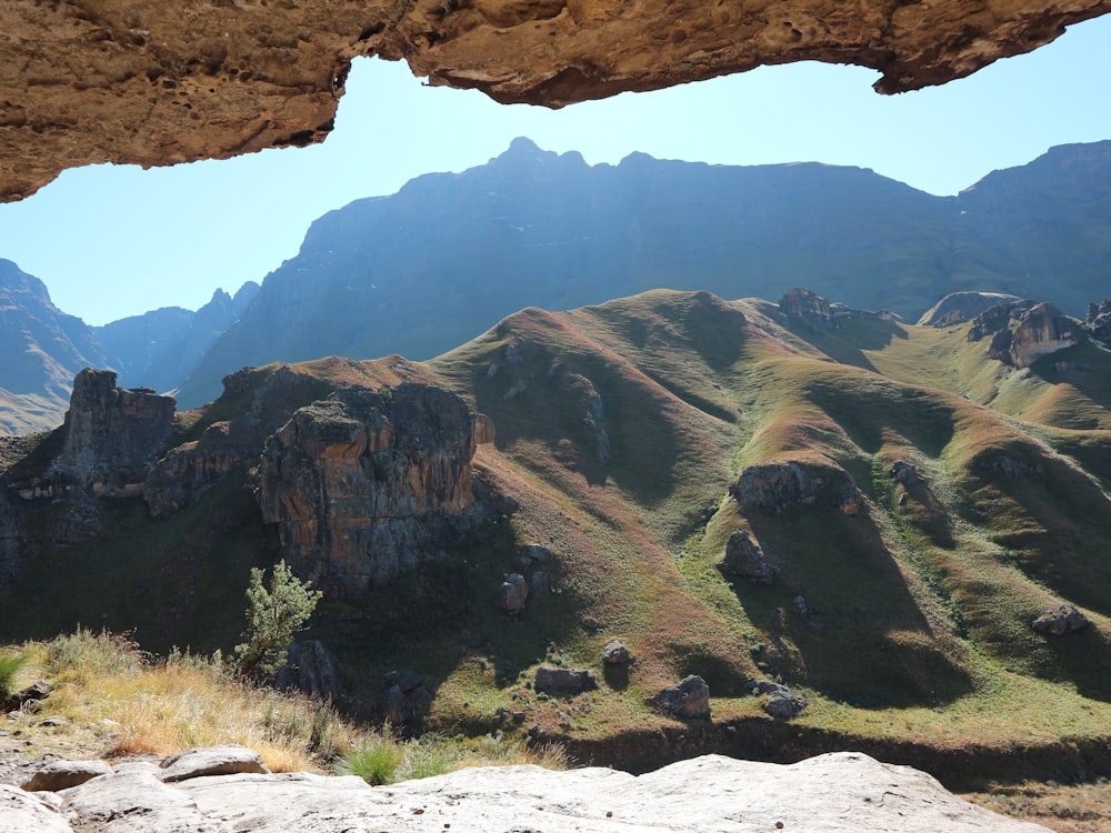 a view of a mountain range from inside a cave
