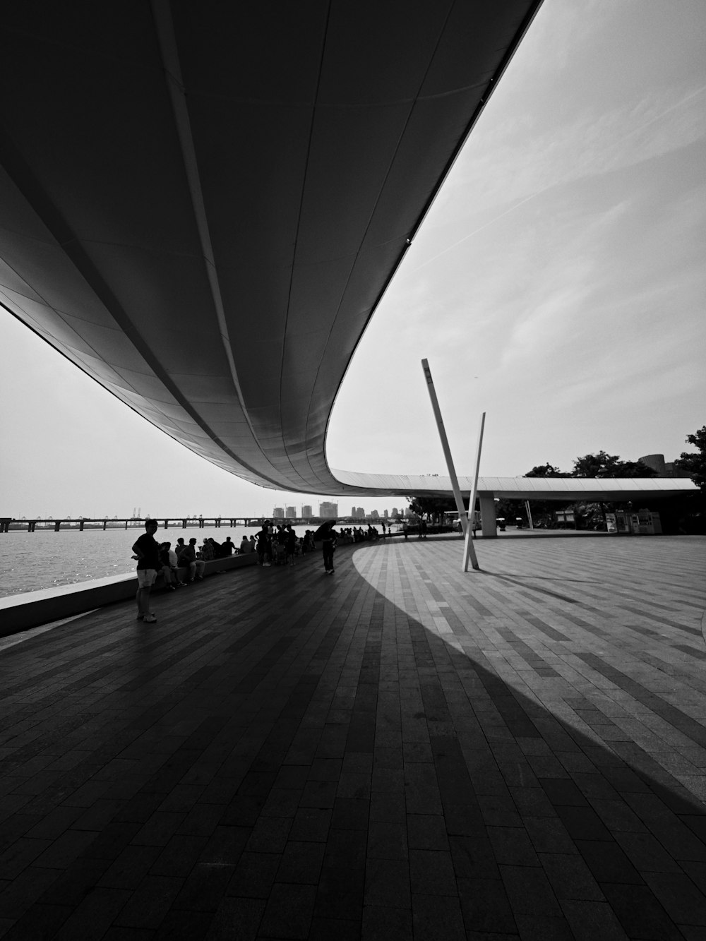 a black and white photo of people sitting on a bench