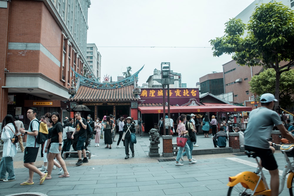 a group of people walking down a street next to tall buildings