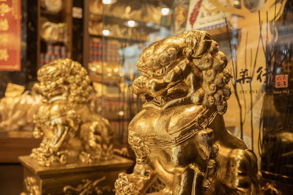 a golden lion statue sitting in front of a store window