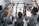 a group of people sitting at a table raising their hands