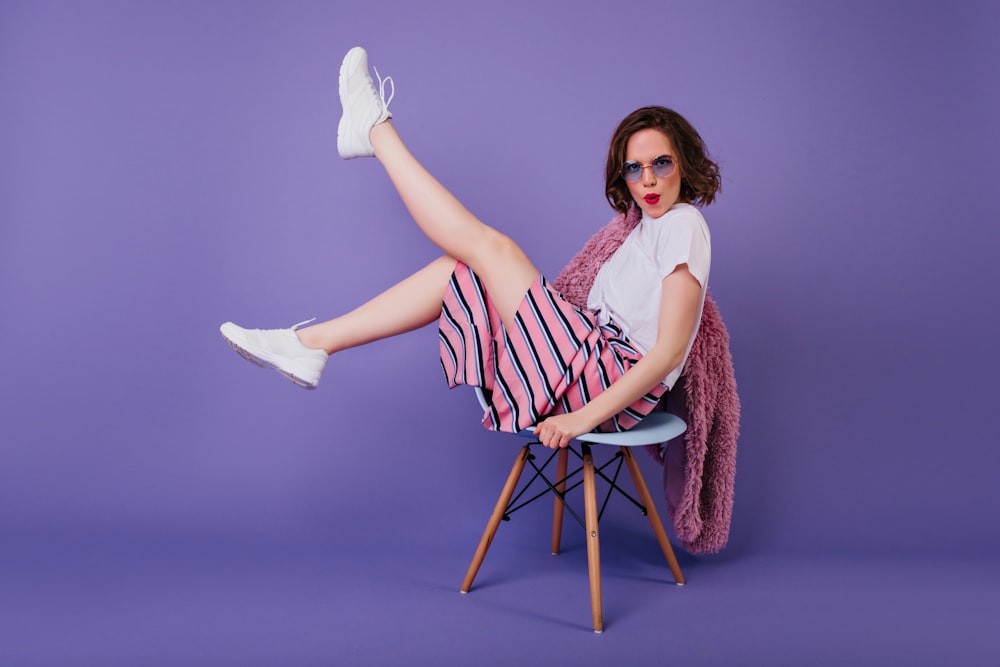 a woman sitting on a chair with her legs crossed