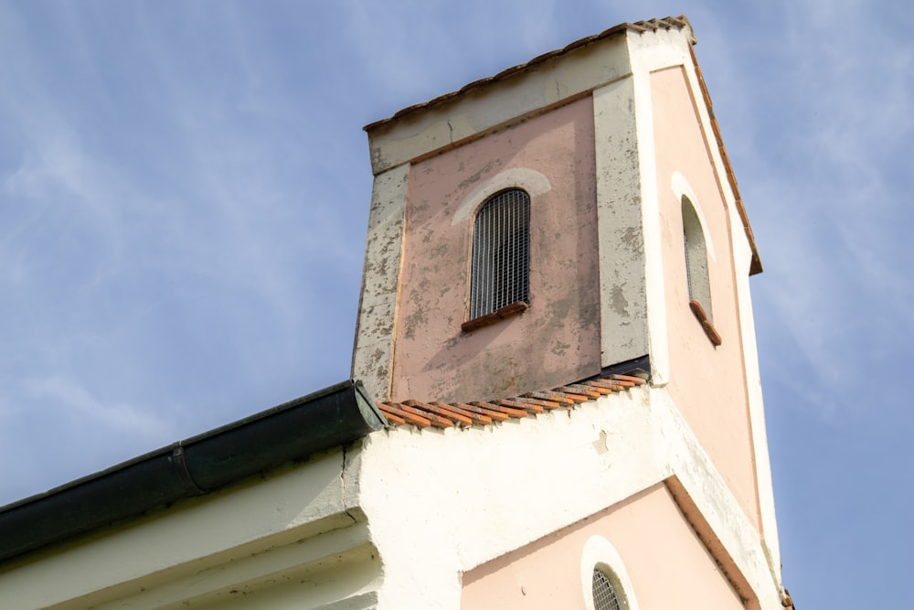 a church steeple with a window and a sky background