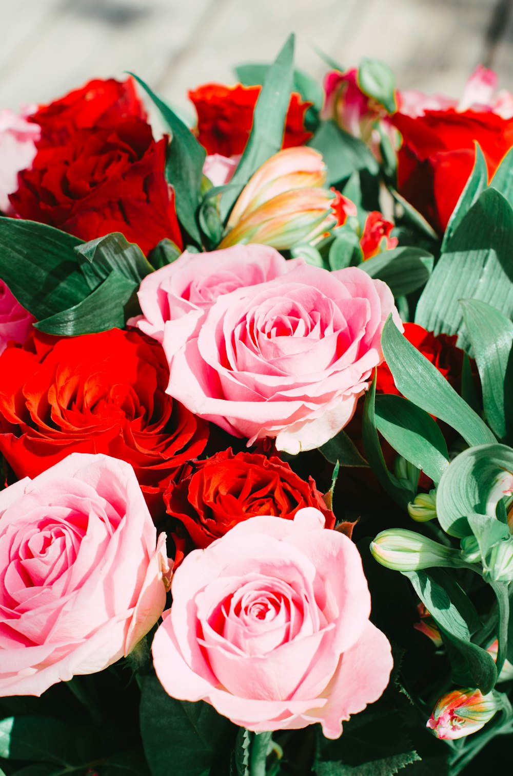 a bouquet of pink and red roses on a table