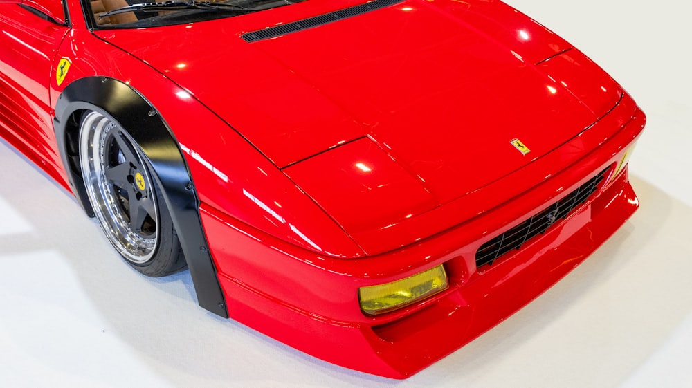 a red sports car parked on a white floor