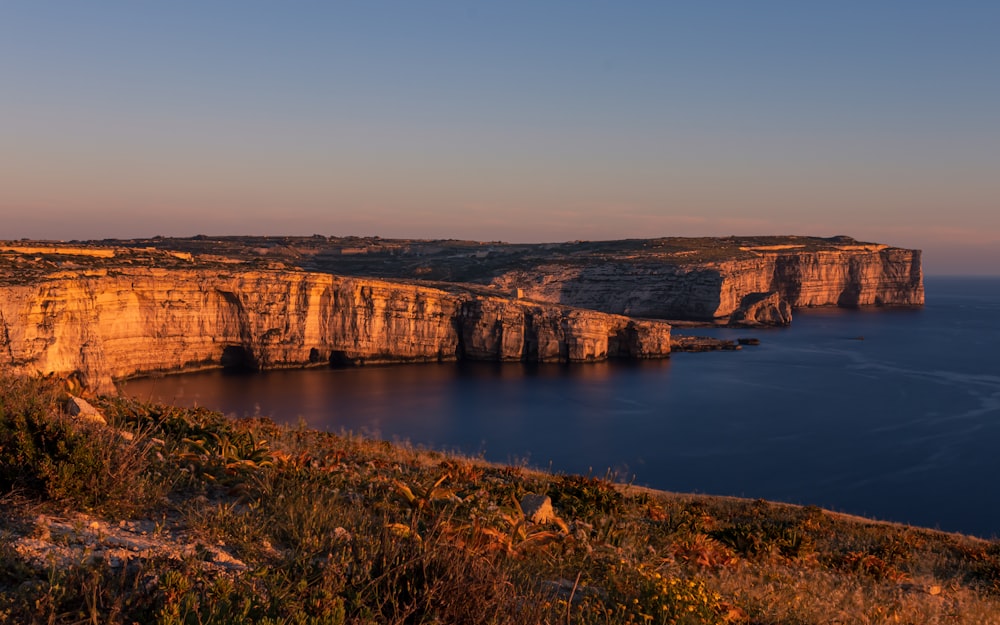 a large body of water sitting next to a cliff