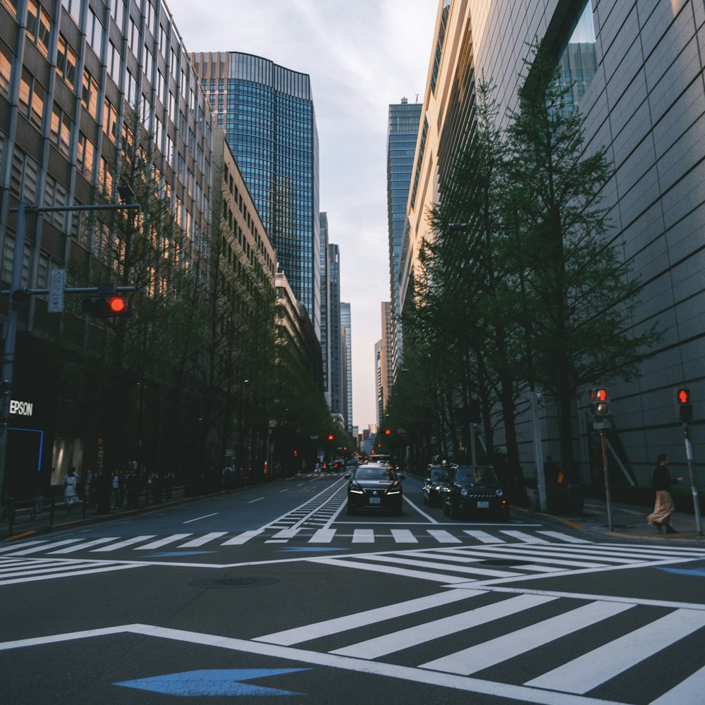 a city street filled with traffic next to tall buildings