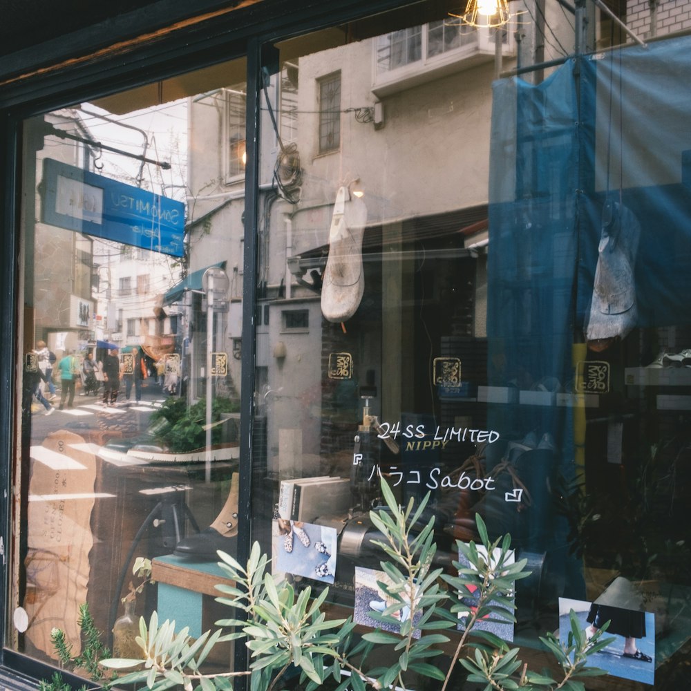 a store front window with plants in the window