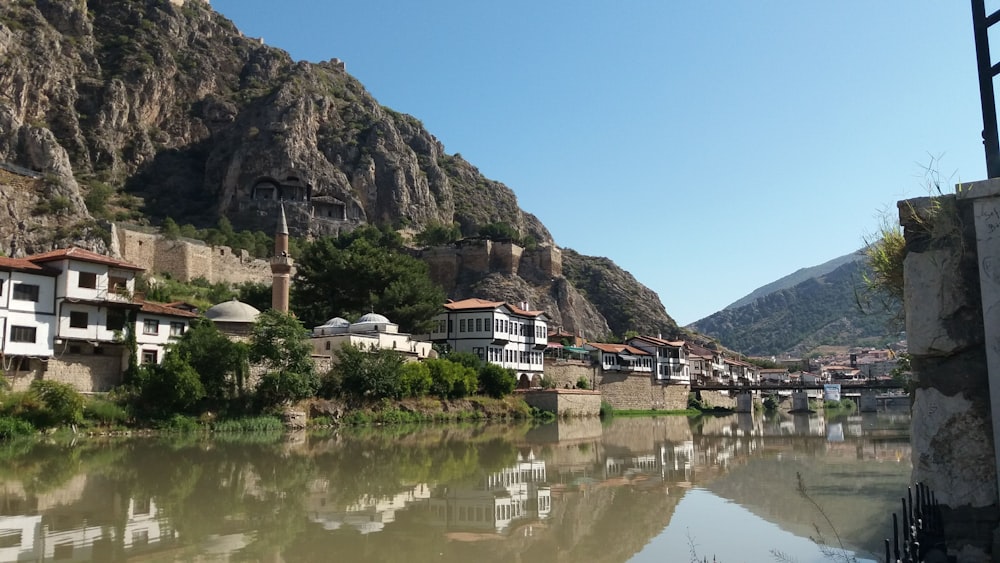 a river running through a small town next to a mountain