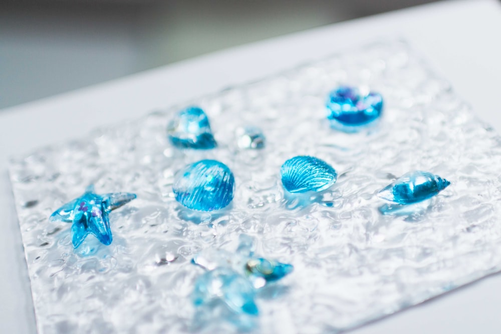 a close up of blue glass beads on a white surface