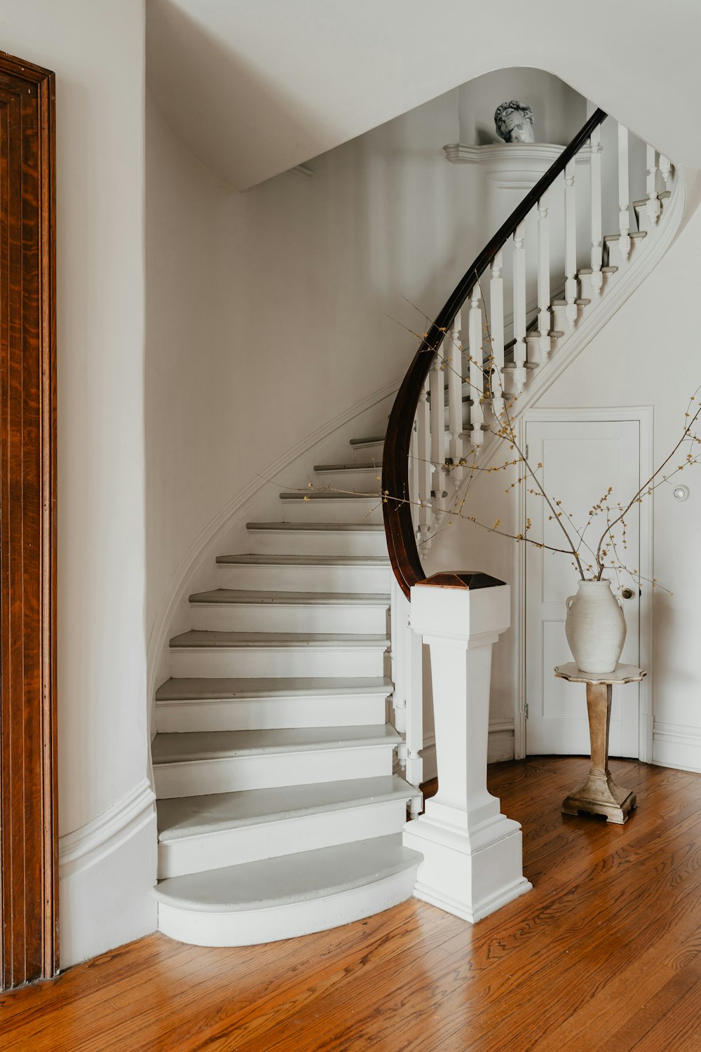 a white staircase in a house with wood floors