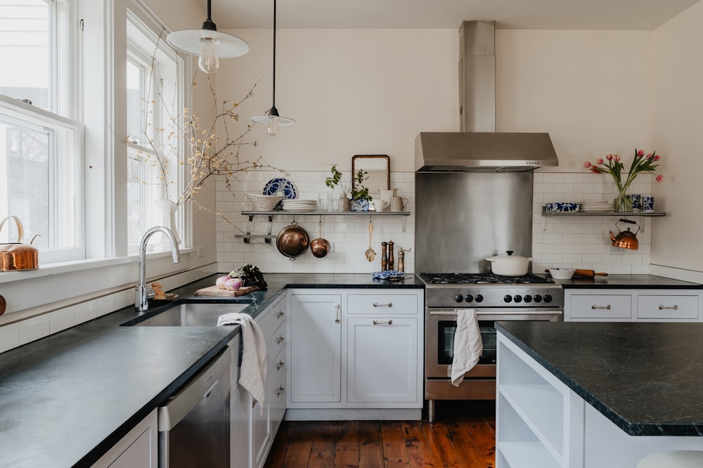 a kitchen with white cabinets and black counter tops