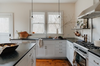 a kitchen with white cabinets and black counter tops
