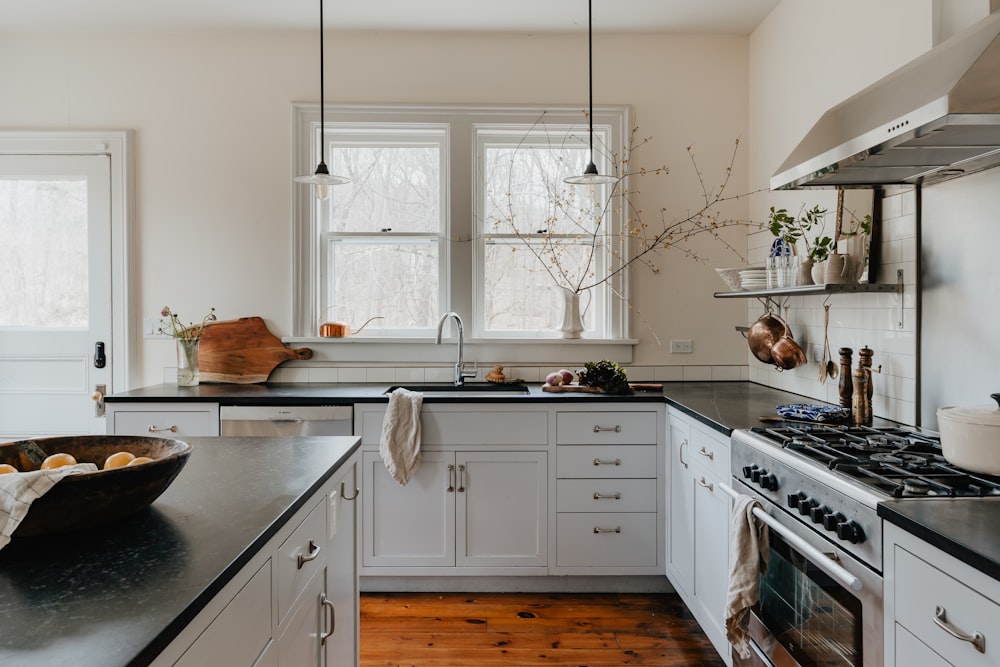 a kitchen with white cabinets and black counter tops