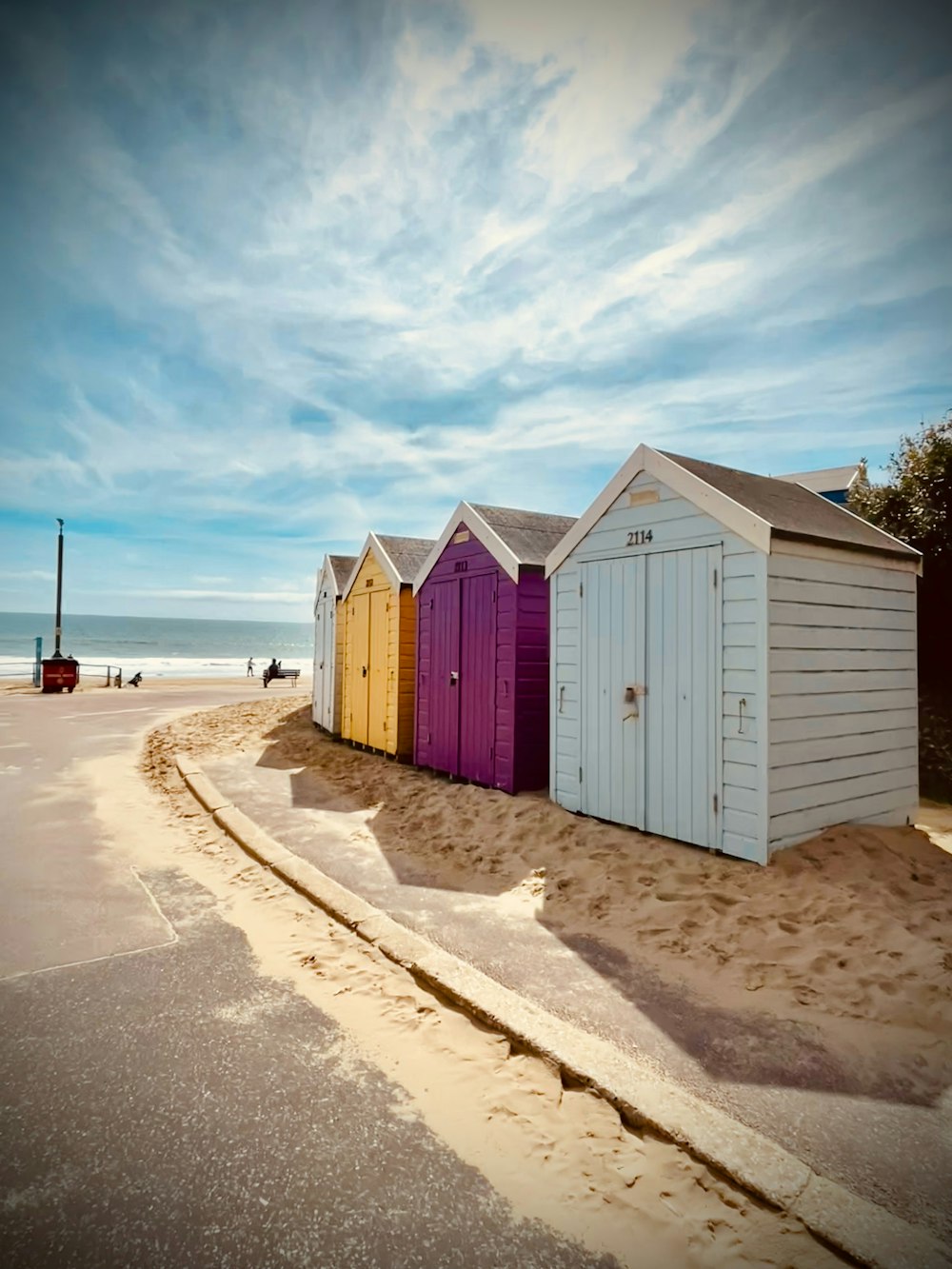 a row of beach huts sitting on top of a sandy beach