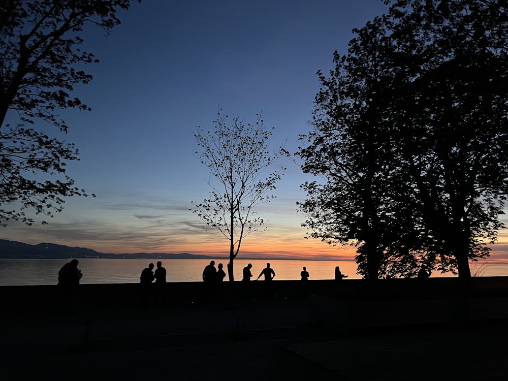 a group of people standing next to each other near a body of water