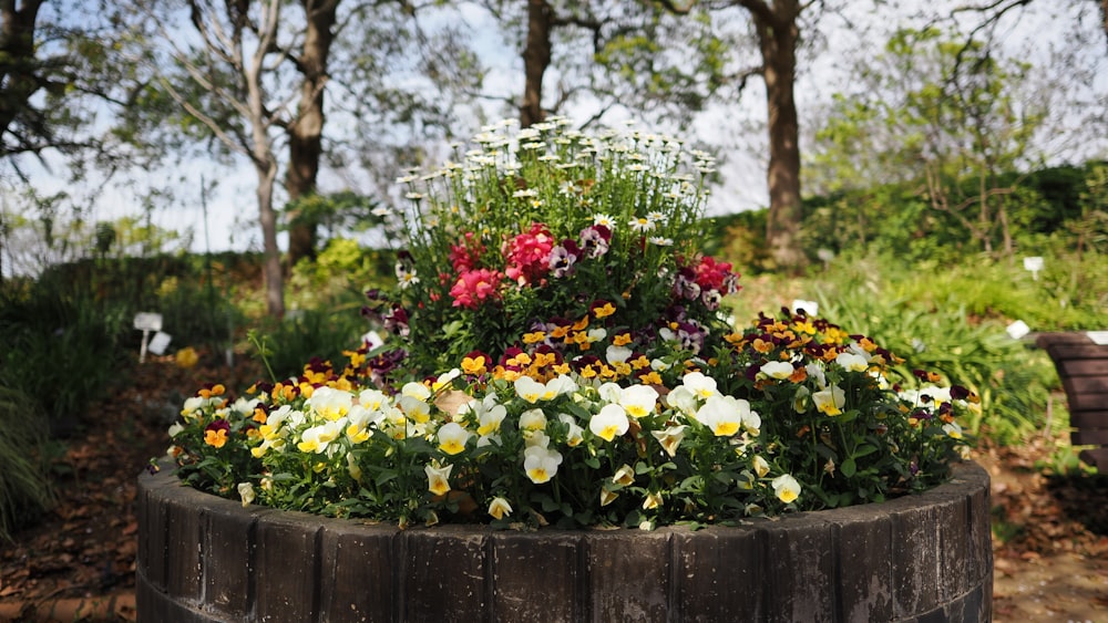 a wooden barrel filled with lots of flowers