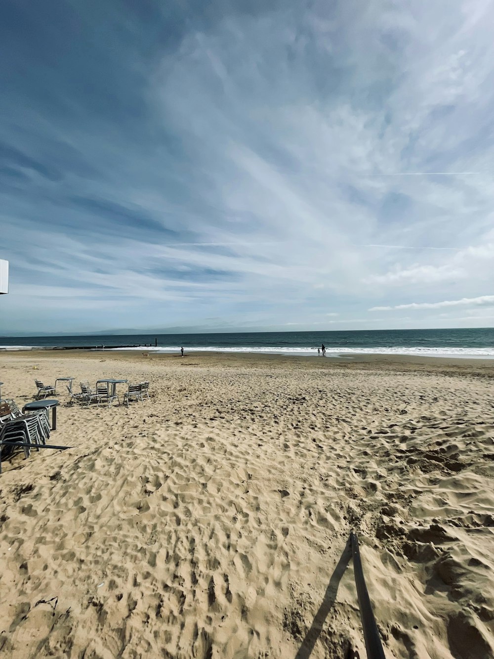 a sandy beach with chairs and a basketball hoop