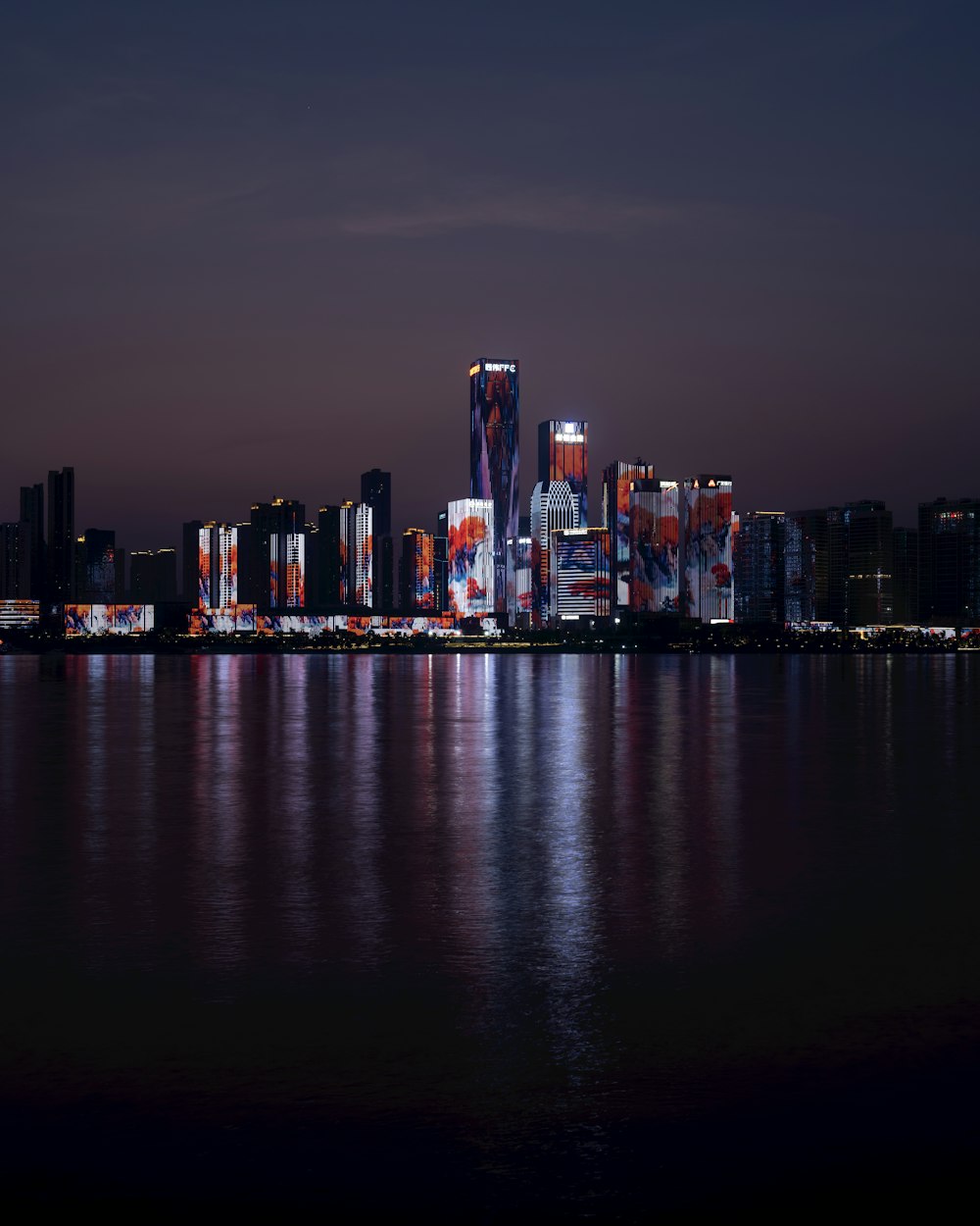 Una vista de una ciudad por la noche desde el otro lado del agua