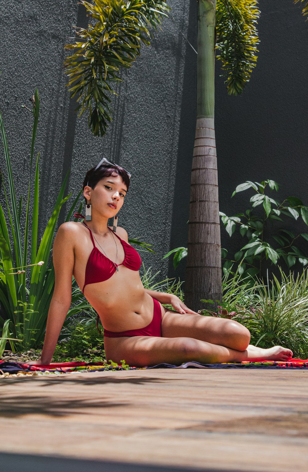 a woman in a red bikini sitting on the ground