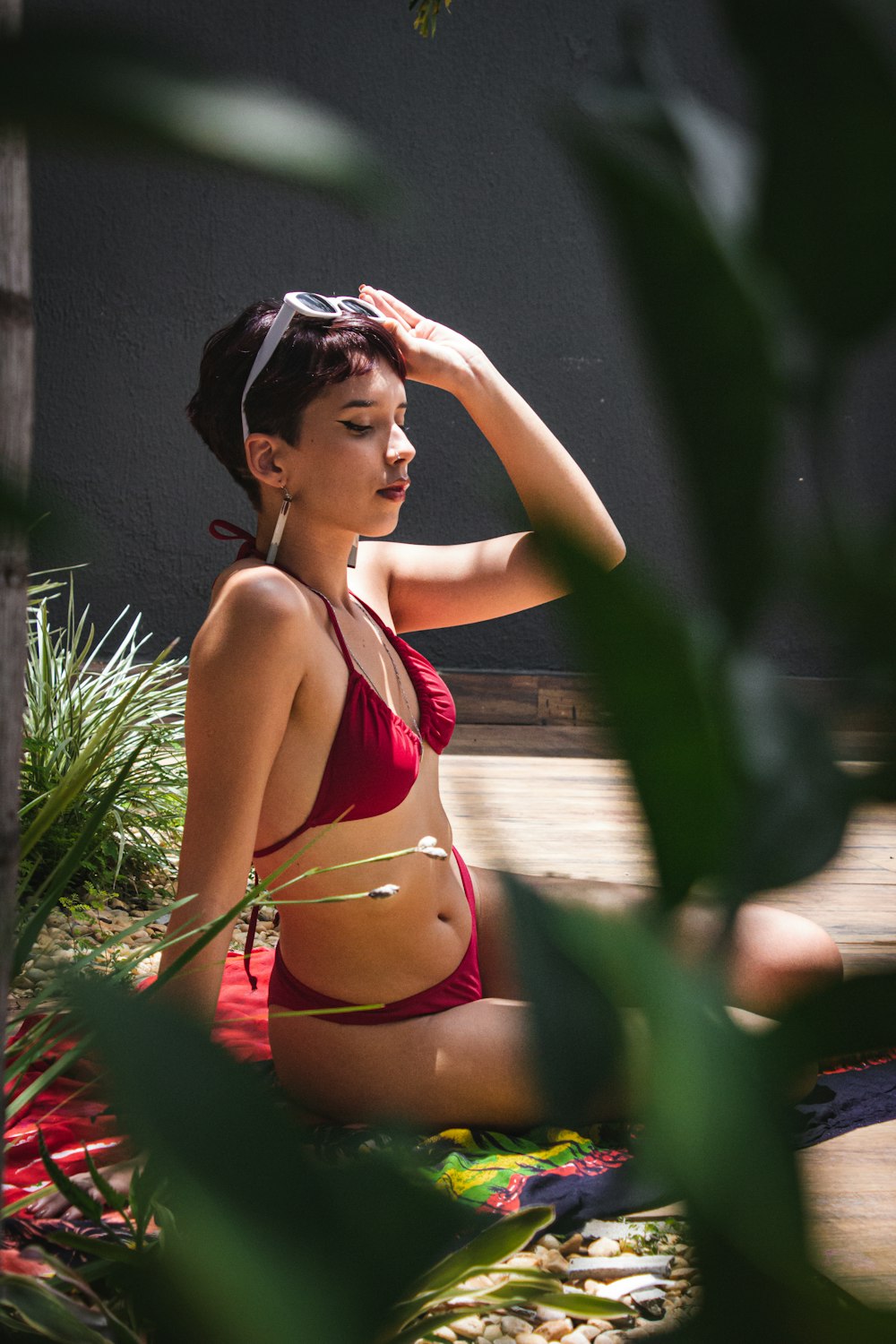 a woman in a red bikini sitting on the ground