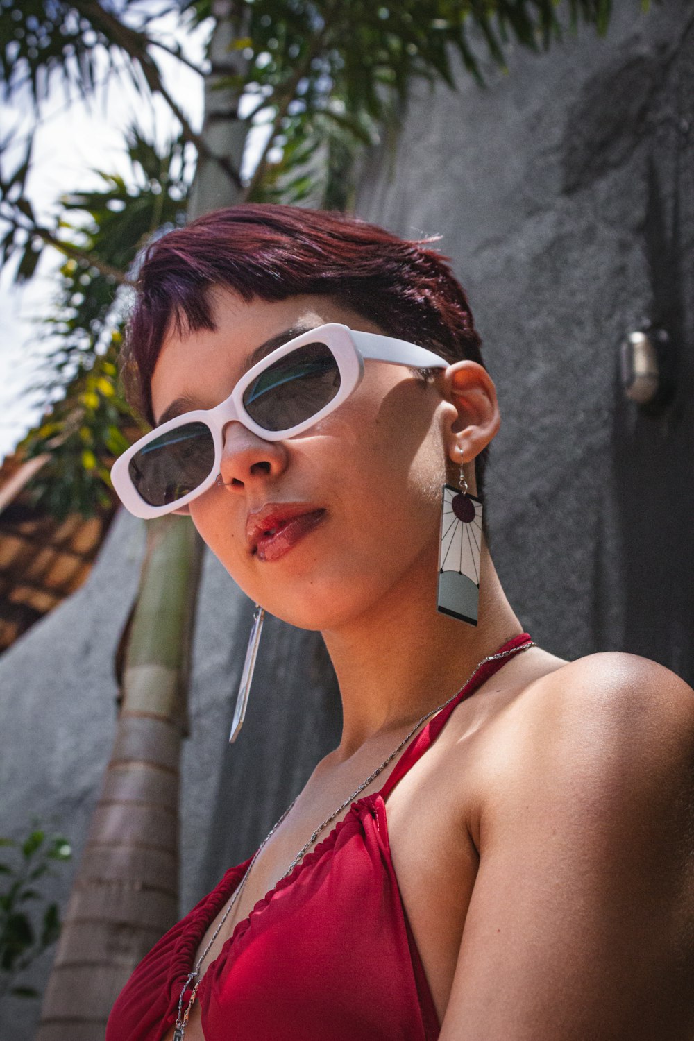 a woman in a red top and white sunglasses