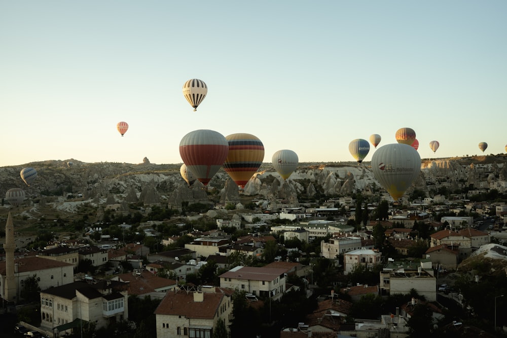 eine Gruppe von Heißluftballons, die über eine Stadt fliegen