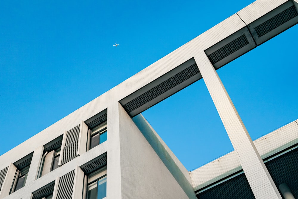 a building with a plane flying in the sky